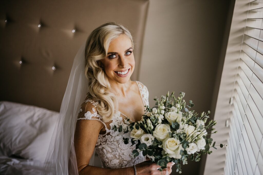 Close-up of a bride holding a cream-colored wedding bouquet – captured by Darren Byrne, Wedding Photographer in Ireland.