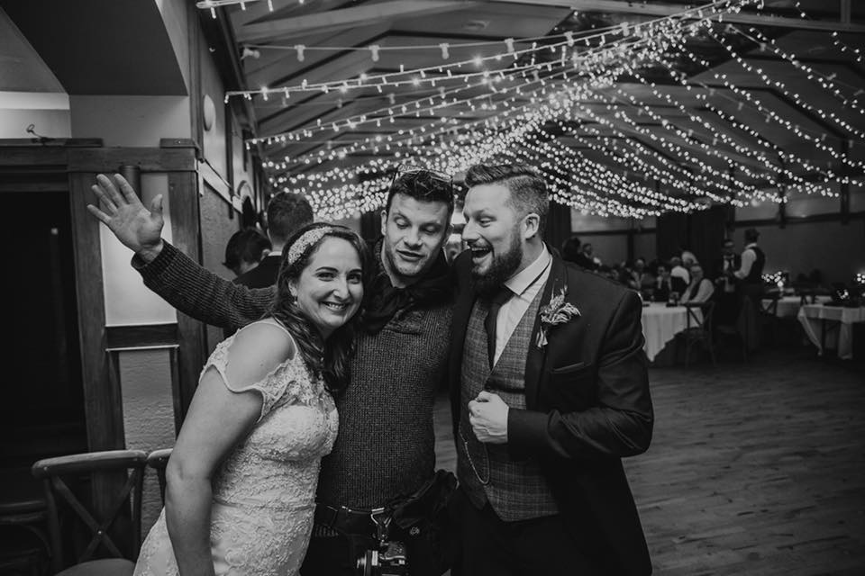 Darren Byrne with a happy wedding couple at their reception, all smiling and celebrating together. Providing some tips about a wedding receiving line.