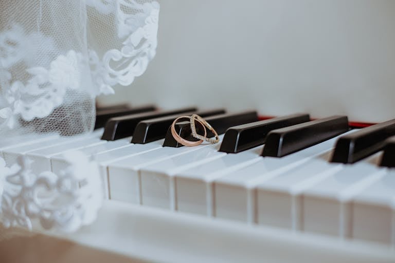 White piano keys with wedding rings placed delicately on top – Darren Byrne, Wedding Photographer in Ireland.