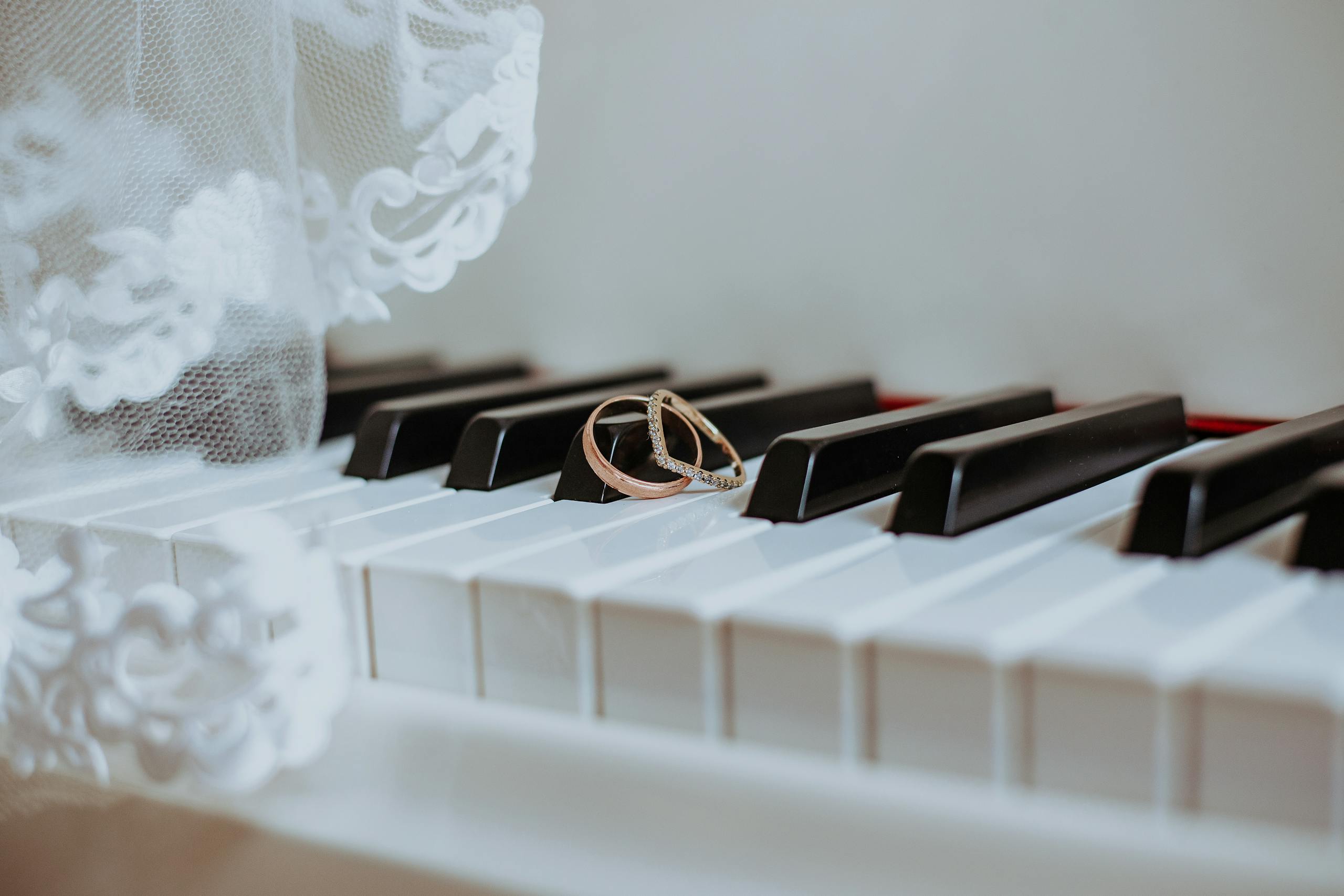 White piano keys with wedding rings placed delicately on top – Darren Byrne, Wedding Photographer in Ireland.