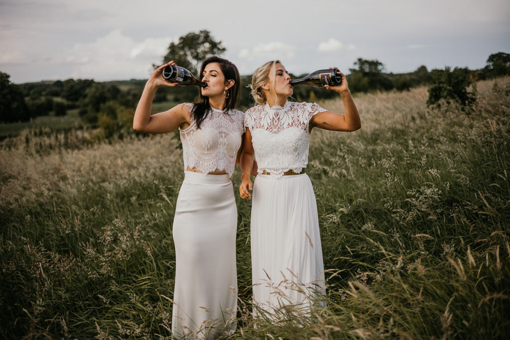 Brides Drinking Champagne Together in a meadow