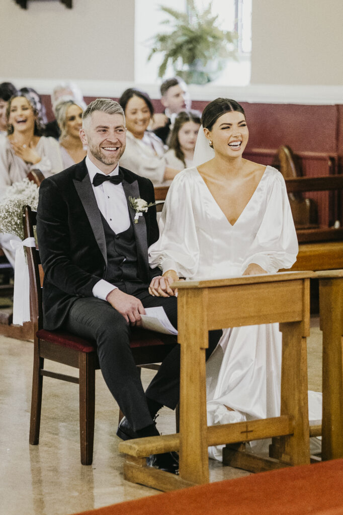 Bride and groom laughing together inside church