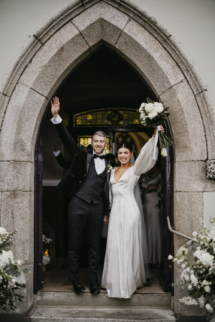 Bride and Groom wave to their guests after their ceremony